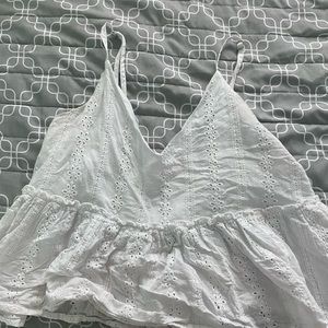 The brand is romwe. It is a white blouse. Flower and circle cut out for detail